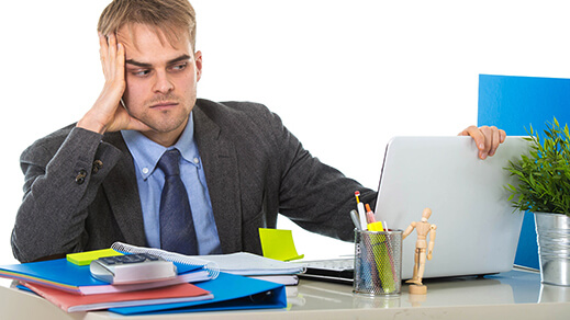 young desperate businessman overworked and upset looking worried and angry sitting at computer desk on white background office in business project stress problem